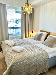 a bedroom with two beds and a chandelier at Brandnew Modern Condo with Sauna in Rovaniemi