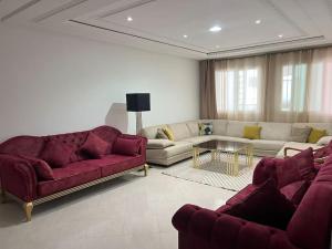 uma sala de estar com dois sofás e uma mesa em Appartement Haut Standing 3 chambres proche gare et centre ville em Kenitra