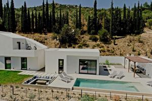 uma casa com uma piscina em frente em Nafplio Villa, pool & sea view em Tolo