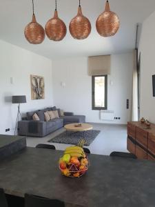 uma sala de estar com uma mesa com uma taça de fruta em Nafplio Villa, pool & sea view em Tolo