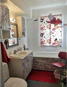 a bathroom with a sink and a window with a bird on it at Kule gule huset in Svolvær