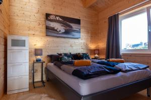 a bedroom with a bed in a wooden wall at Holzhaus in Diemelsee