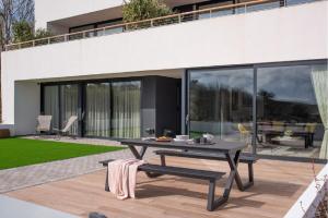 a patio with a picnic table and a house at 1 The Bay - Stunning contemporary flat on the Scottish coast in Coldingham