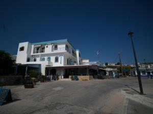 a large white building with a street in front of it at Calypso Hotel in Leipsoi
