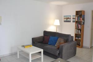 een woonkamer met een bank en een tafel bij L'ESTRAN, 4 kms des plages, port, GR 34 et 2 h 15 Paris LGV in Plérin
