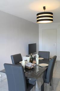 une salle à manger avec une table et des chaises noires dans l'établissement L'ESTRAN, 4 kms des plages, port, GR 34 et 2 h 15 Paris LGV, à Plérin