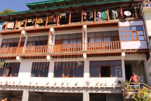 un edificio con persone sui balconi di Hotel Mannat Sach Pass a Tisa