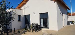 a white house with black windows and a patio at Maison Bord de mer refaite à neuf in Canet-en-Roussillon +6 photos