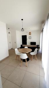 a dining room with a table and two chairs at Maison Bord de mer refaite à neuf in Canet-en-Roussillon