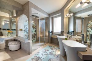 a bathroom with a sink and a toilet and a tub at Hotel Punta Tragara in Capri