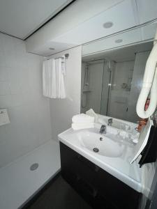 a bathroom with a sink and a shower and a mirror at Hampshire Hotel - 's Gravenhof Zutphen in Zutphen