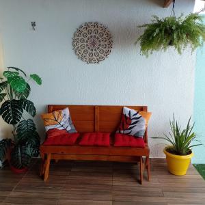 un banco de madera sentado en una habitación con plantas en @vempraarembepe, en Camaçari