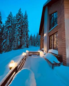 dom w śniegu w nocy w obiekcie Woodland Resort Shkrel w mieście Boge
