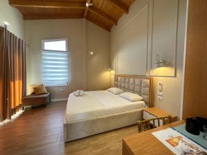 a bedroom with a large bed and a table at Arial Penthouse Suites in Vlorë