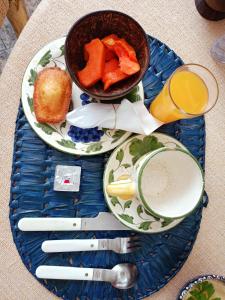 un plato con un tazón de zanahorias y un vaso de zumo en Vila Santa Rosa, en Ilhabela