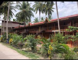 Un edificio con palmeras delante. en Gold India Beach Resort, en Isla Havelock