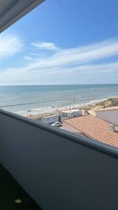 a view of the ocean from a window of a beach at Studio face mer pieds dans l’eau in Saint-Hilaire-de-Riez