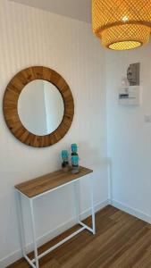 a mirror and a table with two bottles on it at Studio face mer pieds dans l’eau in Saint-Hilaire-de-Riez