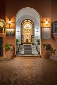 a lobby with a staircase and a chandelier at Hotel Punta Tragara in Capri