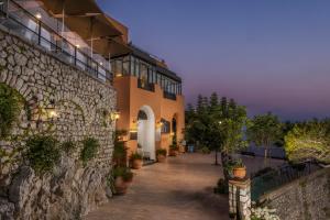 a building with a stone wall and a walkway at Hotel Punta Tragara in Capri