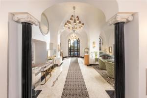 a large hallway with columns and a chandelier at Hotel Punta Tragara in Capri +37 photos
