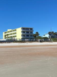 a building on the beach next to a beach at OB Oceanfront Studio - closest to the beach in Ormond Beach