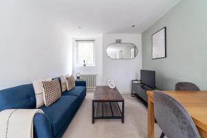 a living room with a blue couch and a table at The Wandsworth Flat in Bromley