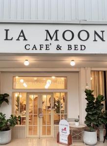 a store with a sign for a mom cafe and bed at La Moon House in Salaya