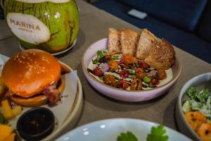 a table with plates of food and a sandwich and salad at Sugar Marina Hotel - FASHION - Kata Beach in Kata Beach