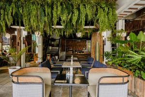 a restaurant with tables and chairs and plants at Sugar Marina Hotel - FASHION - Kata Beach in Kata Beach