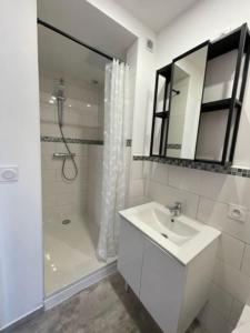 a white bathroom with a sink and a shower at Nid Catalan Climatisé Jardin Centre-ville Plage in Perpignan