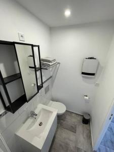 a white bathroom with a sink and a toilet at Nid Catalan Climatisé Jardin Centre-ville Plage in Perpignan