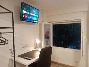 a room with a desk and a television on the wall at Private Room Service - Grupo RH Santander in Santander