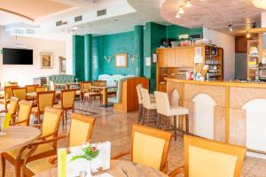 un restaurante con mesas y sillas y un bar en Centro Vacanze La Limonaia, en Limone sul Garda