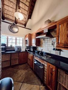 a kitchen with wooden cabinets and a stove top oven at Tholo Private Game Lodge in Bela-Bela