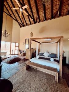 een slaapkamer met een houten bed in een kamer bij Tholo Private Game Lodge in Bela-Bela