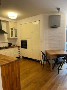 a kitchen with a table and a television on the wall at Family apartment on Saska Kępa in Warsaw