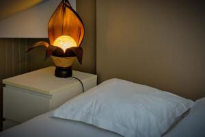 une lampe assise sur une table de nuit à côté d'un lit dans l'établissement Le Nature, un joli F2 au cœur de Rouen Rive Droite, à Rouen