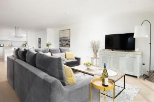 a living room with a grey couch and a table at 1 The Bay - Stunning contemporary flat on the Scottish coast in Coldingham