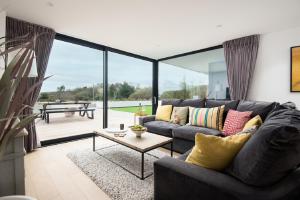 a living room with a couch and a table at 1 The Bay - Stunning contemporary flat on the Scottish coast in Coldingham