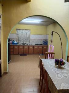 een eetkamer met een tafel en een keuken bij Iman homestay in Lunas