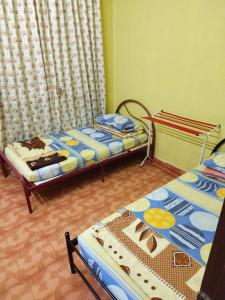twee bedden in een kamer met gordijnen bij Iman homestay in Lunas