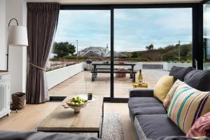 a living room with a couch and a table at 1 The Bay - Stunning contemporary flat on the Scottish coast in Coldingham