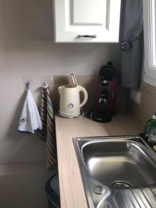a kitchen counter with a sink and a cup on it at maison indépendante avec jardin in Senlis