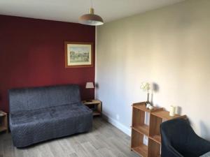 a living room with a couch and a table at maison indépendante avec jardin in Senlis +1 photo