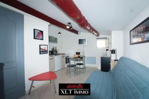 a living room with a blue bed and a kitchen at Studio île Martigues in Martigues