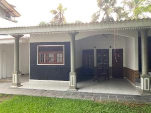 a house with a porch with columns and a patio at Island Star POOL & SPA in Galle