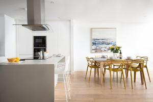 a kitchen and dining room with a table and chairs at 1 The Bay - Stunning contemporary flat on the Scottish coast in Coldingham