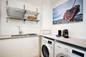 a kitchen with a washing machine and a sink at 1 The Bay - Stunning contemporary flat on the Scottish coast in Coldingham