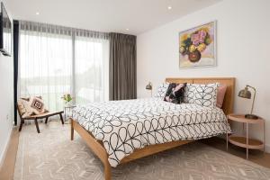 a bedroom with a bed and a large window at 1 The Bay - Stunning contemporary flat on the Scottish coast in Coldingham